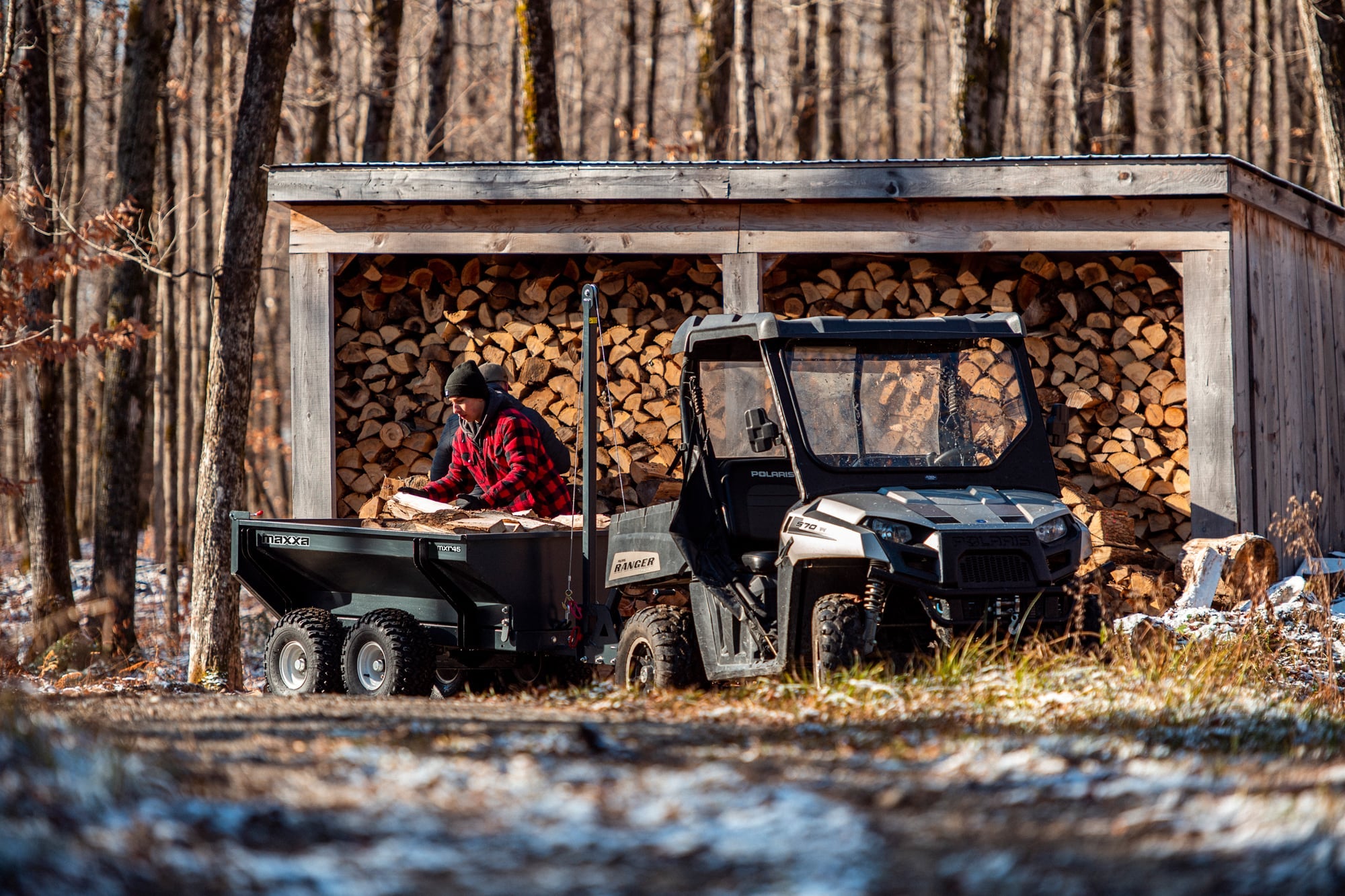 Remorque utilitaire Maxxa MXR46 en action avec un ATV utilisé pour transporter des buches de bois